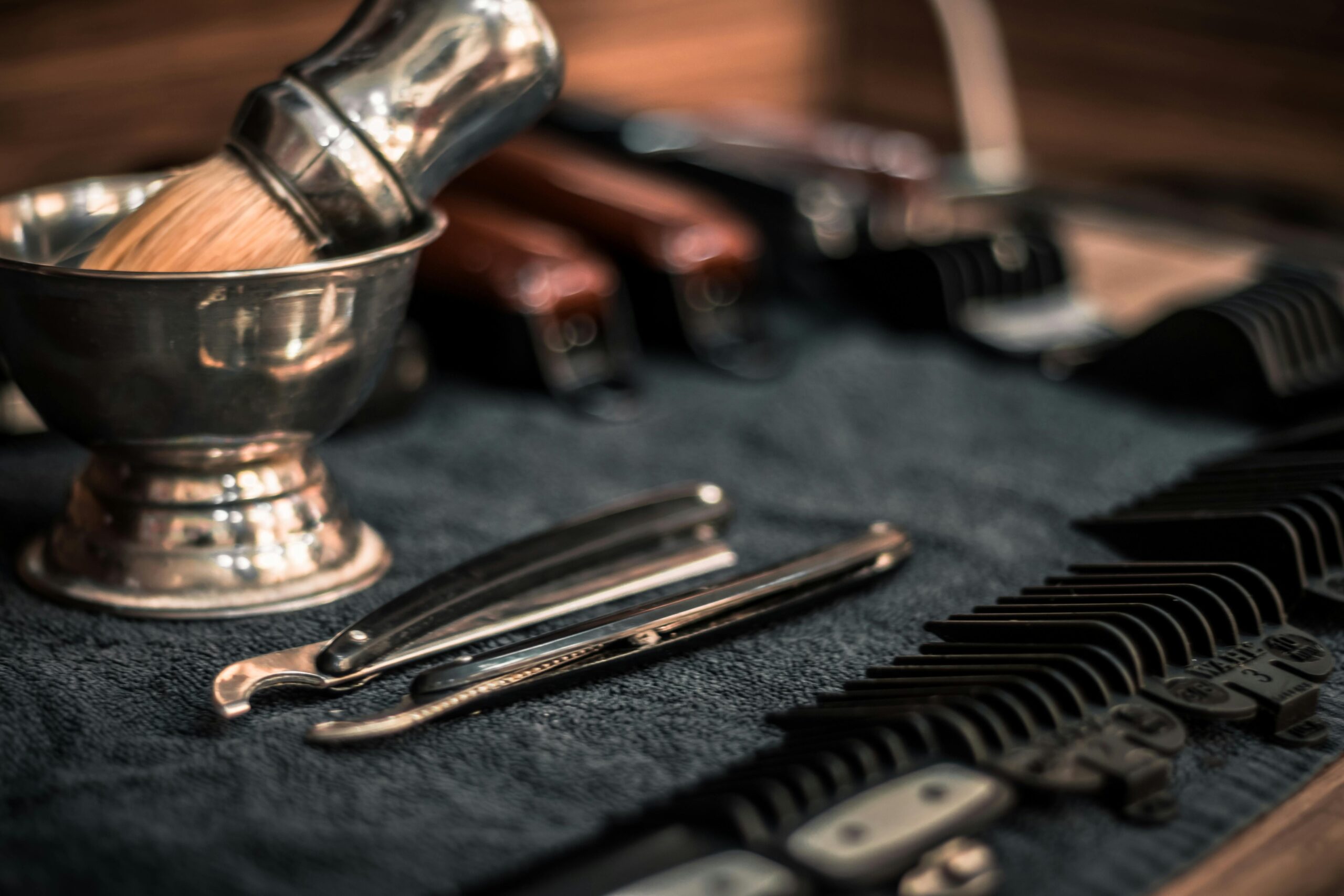 Close-up of neatly arranged barber tools, including razors and combs, highlighting precision.